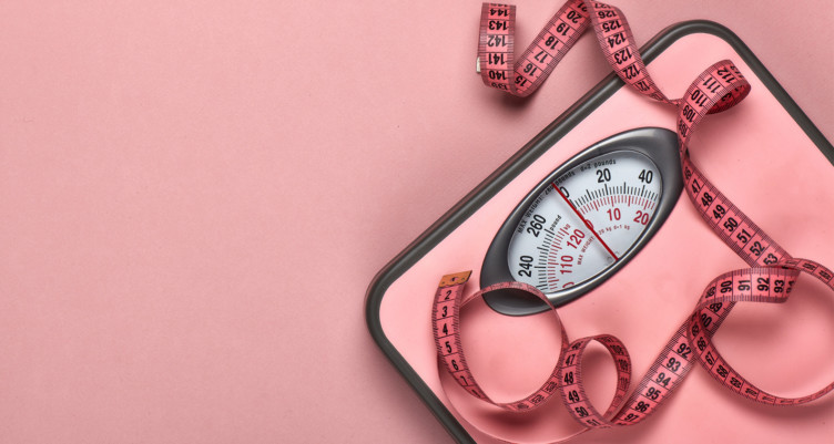 Image of a pink bathroom scale on a pink background