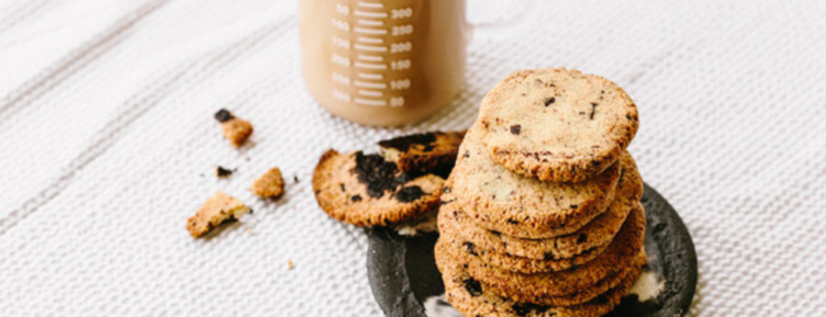 Stack of chocolate chip cookies next to beaker