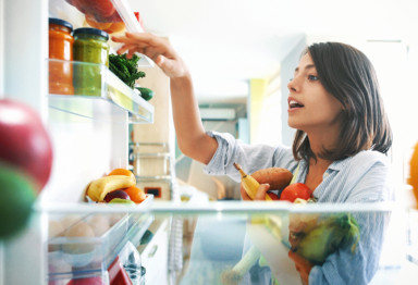 Woman selecting ingredients from fridge