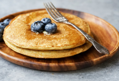 A short stack of blueberry pancakes with a fork