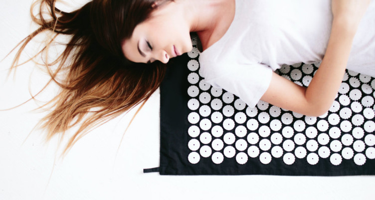 Woman laying on acupressure mat