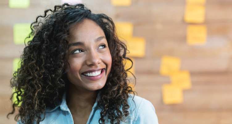 Woman smiling in front of wall