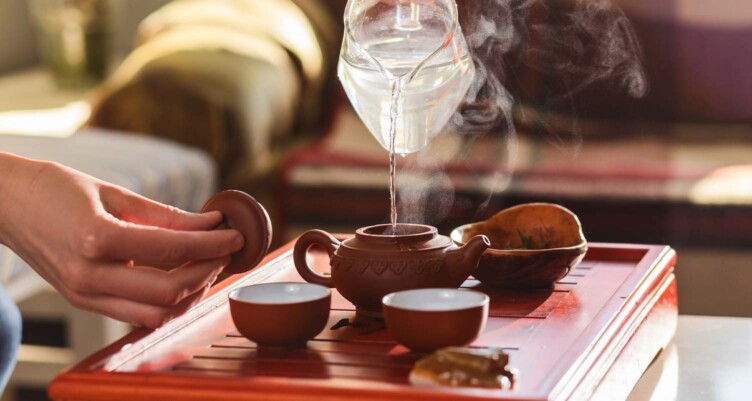 hand pouring hot water into tea kettle