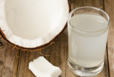 Coconut half sitting next to coconut water