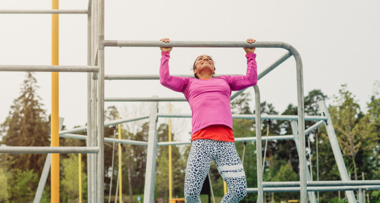 woman doing pull-ups outdoors