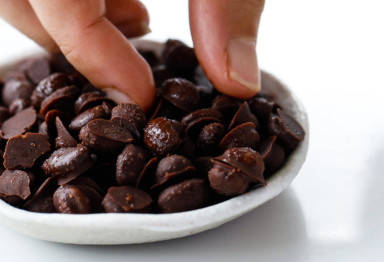 Chocolate covered coffee beans in white bowl