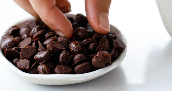 Chocolate covered coffee beans in white bowl