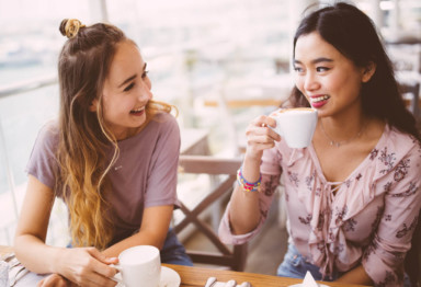 Women drinking oat milk lattes at a cafe