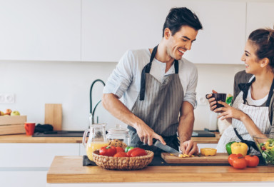 Two people cooking food in kitchen