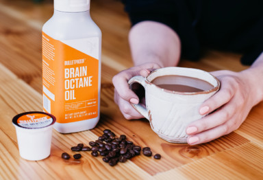 Person holding mug of coffee and Brain Octane MCT oil