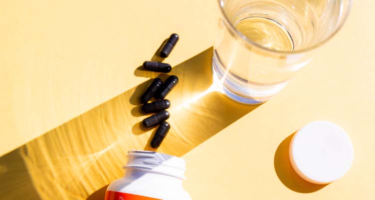 Charcoal pills next to water