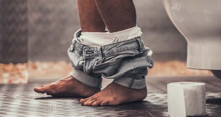 person with pants down in bathroom