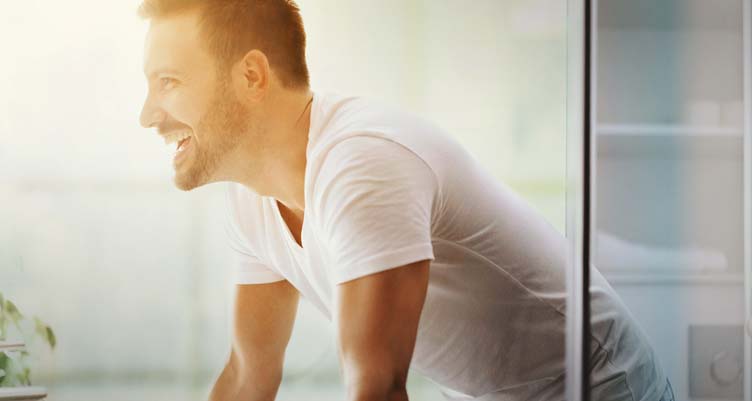 man sitting down in bathroom on toilet