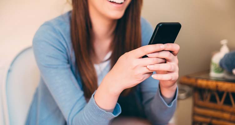 woman looking at phone while sitting on toilet