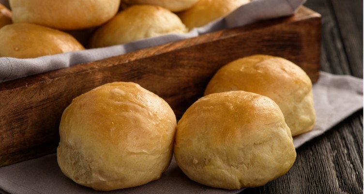 a basket of dinner rolls on a table