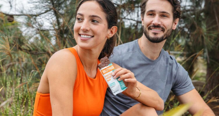 Friends sitting down after a hike with a Bulletproof protein bar