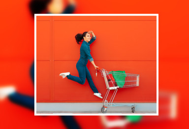 Woman jumping pushing shopping cart