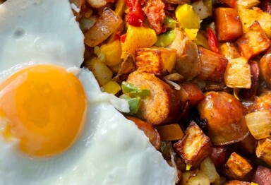 A paleo breakfast plate of eggs and sausage hash