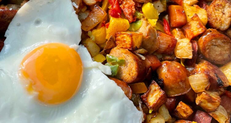 A paleo breakfast plate of eggs and sausage hash