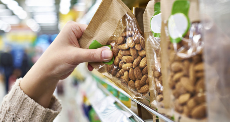 Person pulling almonds off shelf