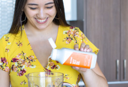 Woman pouring MCT oil into blender