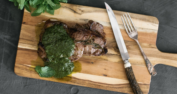 steak with chimichurri on a cutting board