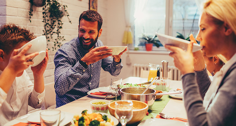 Friends eating dinner around table