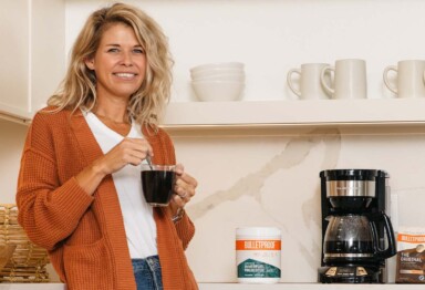 Blonde woman leaning on kitchen counter drinking Bulletproof Innerfuel Prebiotic Coffee