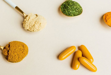 Spoons filled with supplements and curcumin pills