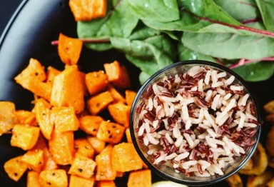 A small bowl of rice, diced sweet potatoes and salad on a plate