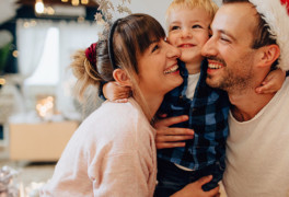Smiling family with father wearing Santa hat