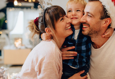 Smiling family with father wearing Santa hat