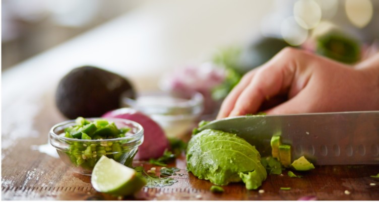 Person slicing avocados on cutting board