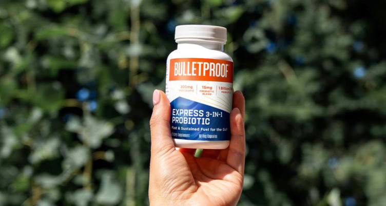 Holding up a bottle of Bulletproof Express 3-in-1 Probiotic
