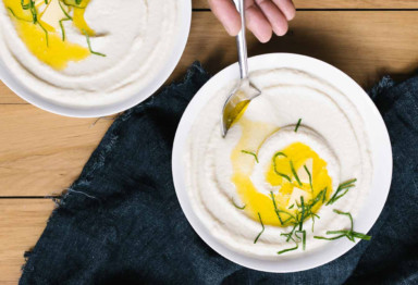 Two bowls of cauliflower soup topped with butter