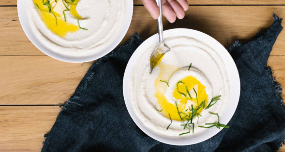 Two bowls of cauliflower soup topped with butter