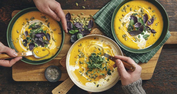 People enjoying soup on table
