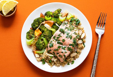 Plate of salmon and vegetables on orange table