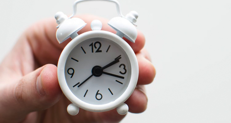 Person holding alarm clock