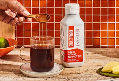 Bulletproof Brain Octane oil being poured into mug of coffee