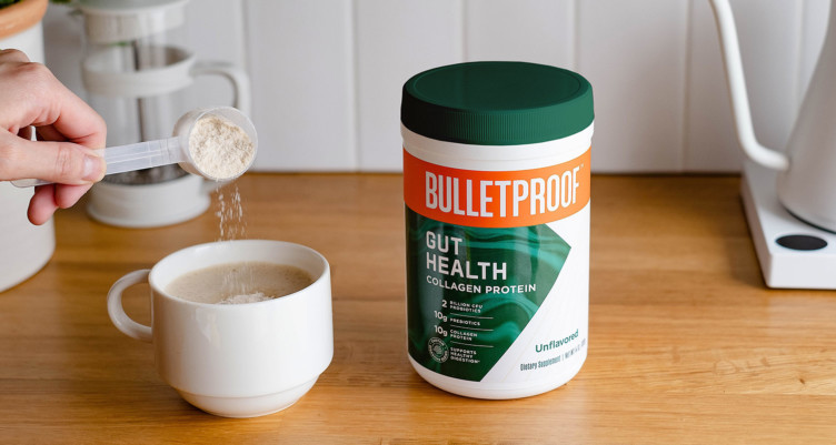 Adding a scoop of Bulletproof Unflavored Gut Health Collagen Protein to a mug