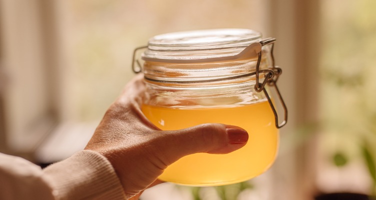 Hand holding jar of ghee