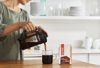 Woman pouring Bulletproof coffee into mug