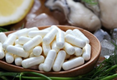 Zinc supplements in spoon next to oyster