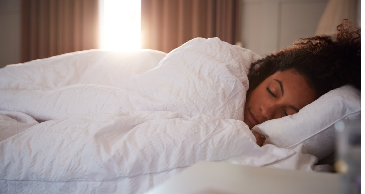 Woman sleeping in white bed