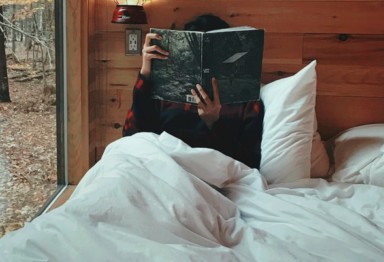 Woman reading in bed in cabin