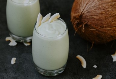 Paleo coconut avocado smoothie next to coconut