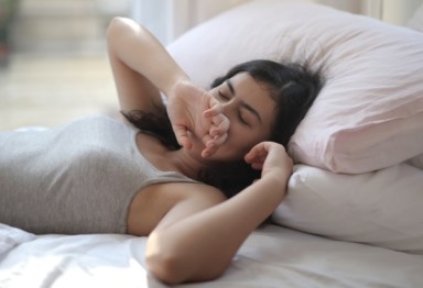 Woman yawning in bed