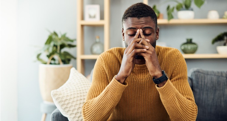 Stressed man in yellow sweater at home