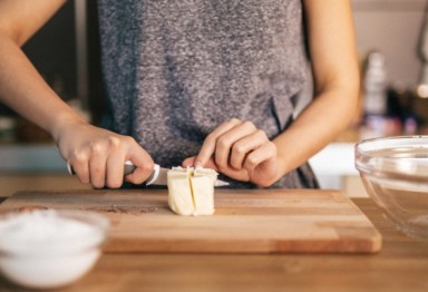 Woman slicing butter on cutting board